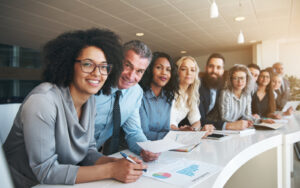 A group of workers smiling at the camera wearing different types of clothes