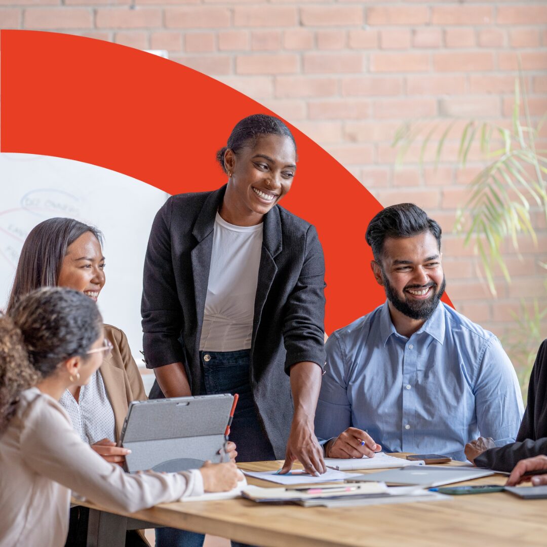Photo shows a diverse group of co-workers preparing for National Inclusion Week. Image is intersected with a red arch.