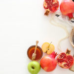 A table of honey, apples and pomegranates
